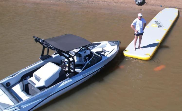 A Man is Standing Next to a Boat in the Water — OSP Automotive & Marine In Grafton, NSW
