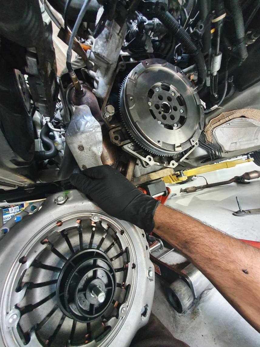 A Man Wearing Black Gloves is Working on a Car Engine — OSP Automotive & Marine In Grafton, NSW