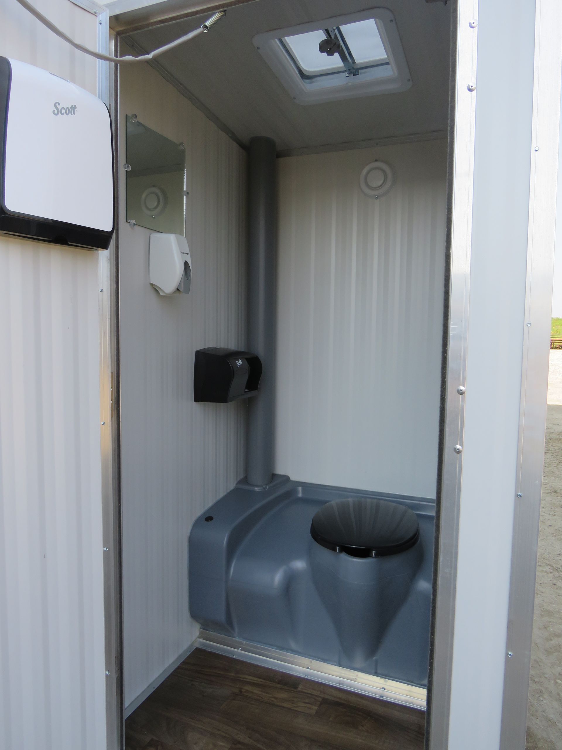 Compact interior of washroom trailers featuring a basic toilet and sanitation setup.