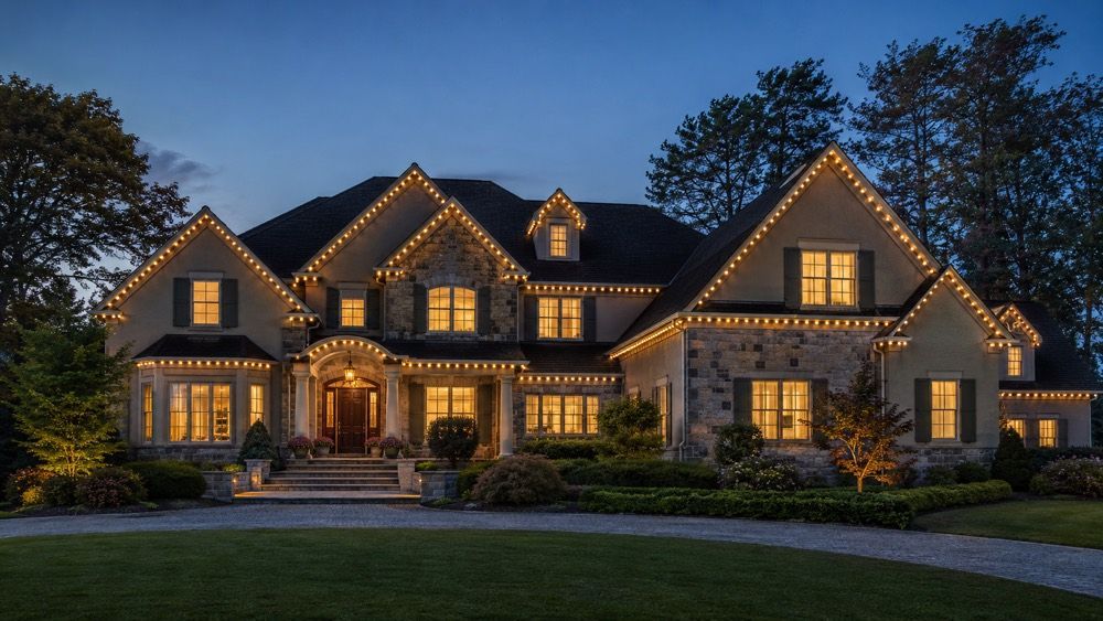 Large Pennsylvania Main Line home with permanent warm-white Smart Roofline lighting