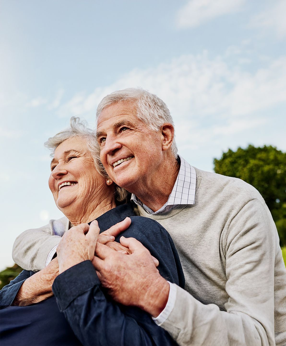 A man and a woman are hugging each other and smiling.