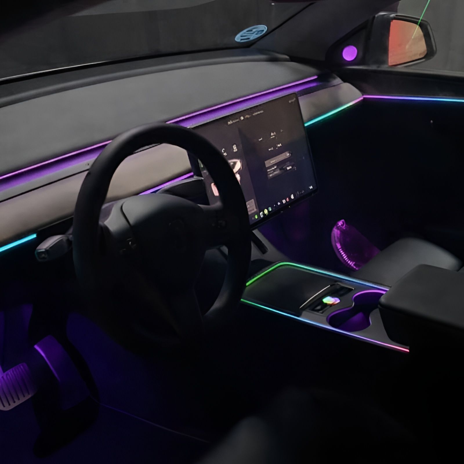 Futuristic car interior with purple and cyan LED lighting, touchscreen dashboard, and illuminated center console.