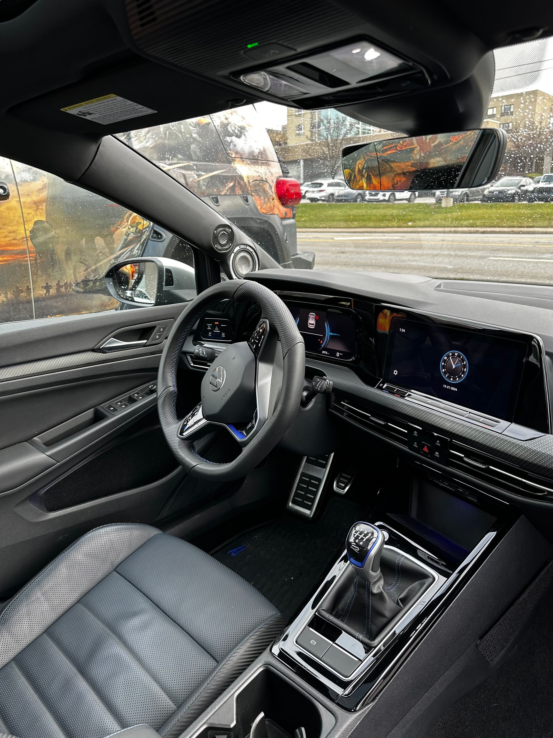 Luxury car interior with black quilted seats, digital dashboard, and center console, viewed from the driver’s seat.