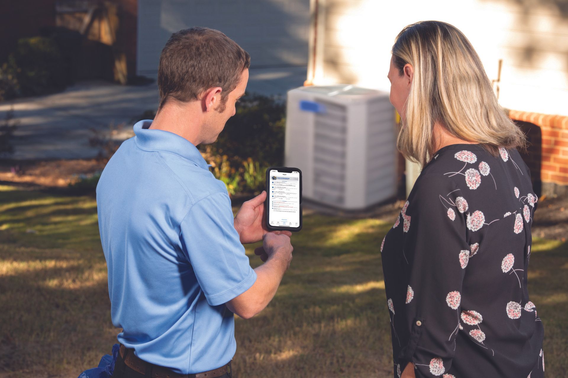 A man and a woman are looking at a cell phone
