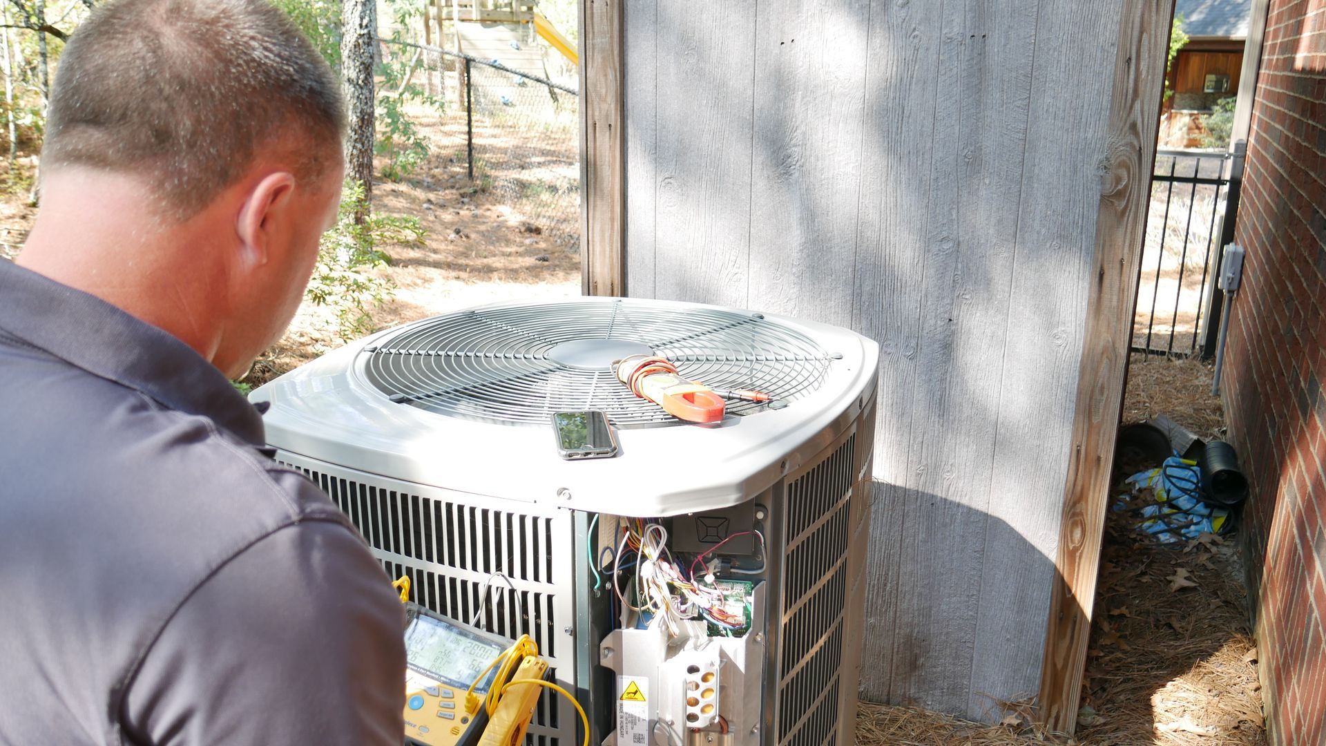 a man is working on an air conditioner outside of a building .
