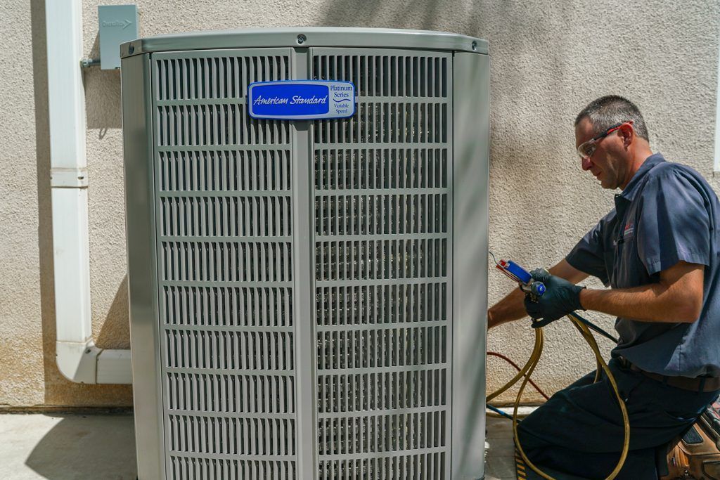 A man is working on an air conditioner outside