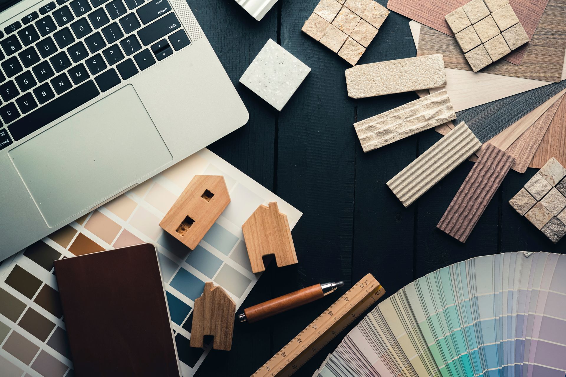 Interior design workspace with color swatches, material samples, and laptop.