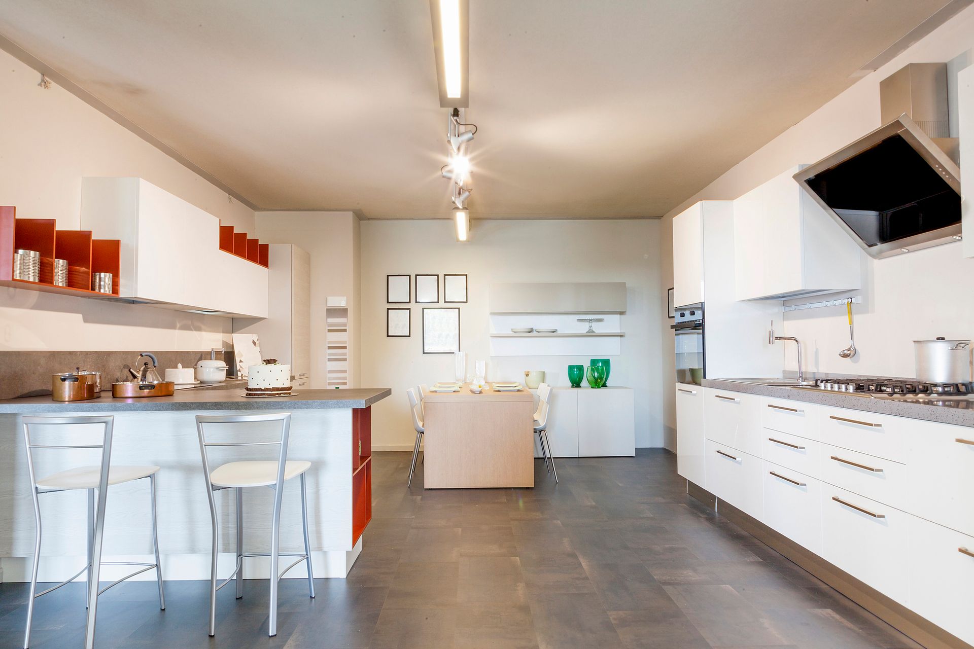 Modern white kitchen showroom with island seating, built-in appliances, minimalist cabinetry decor.