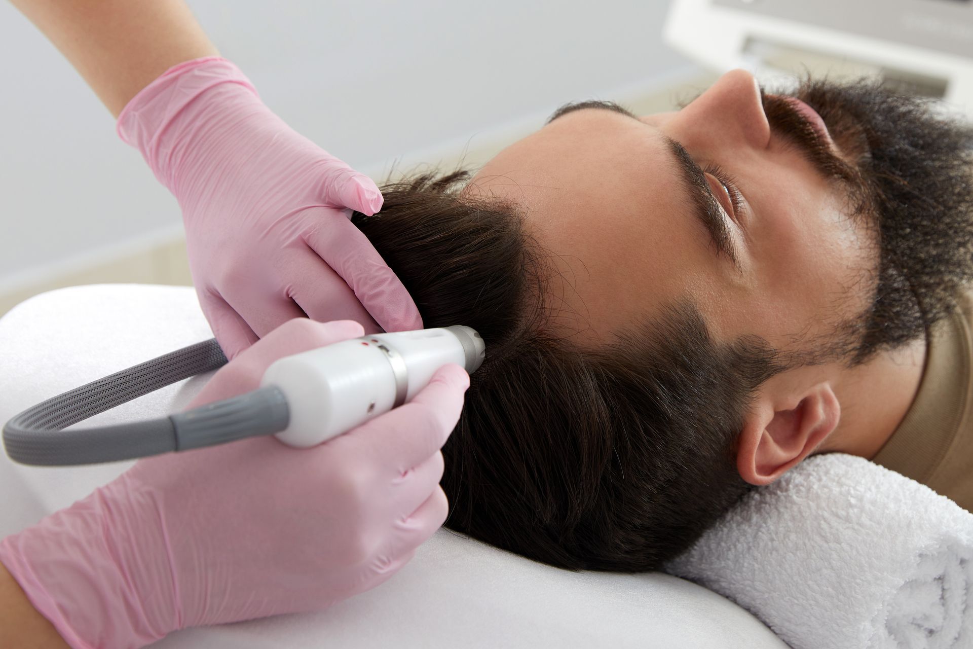 A man is getting a hair treatment at a salon.
