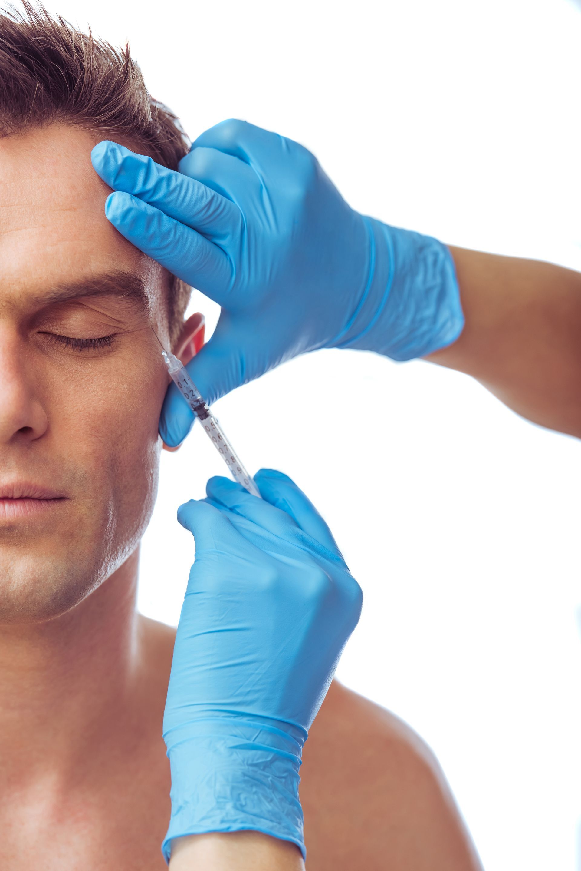 A man is getting a botox injection on his forehead
