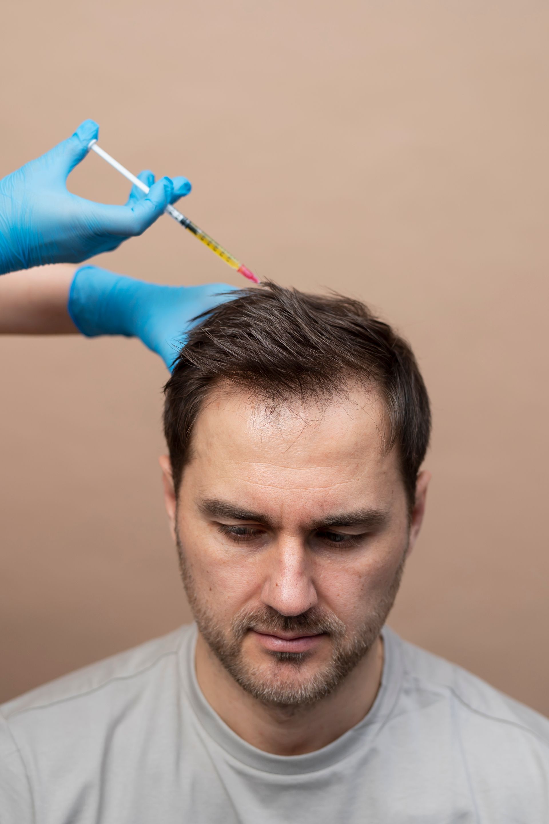 A man is getting an injection in his hair.