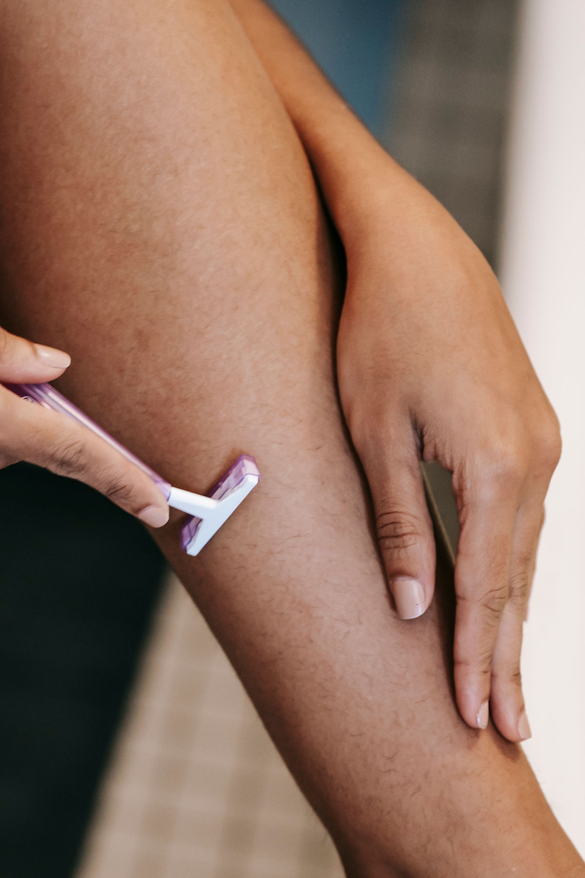 A woman is shaving her legs