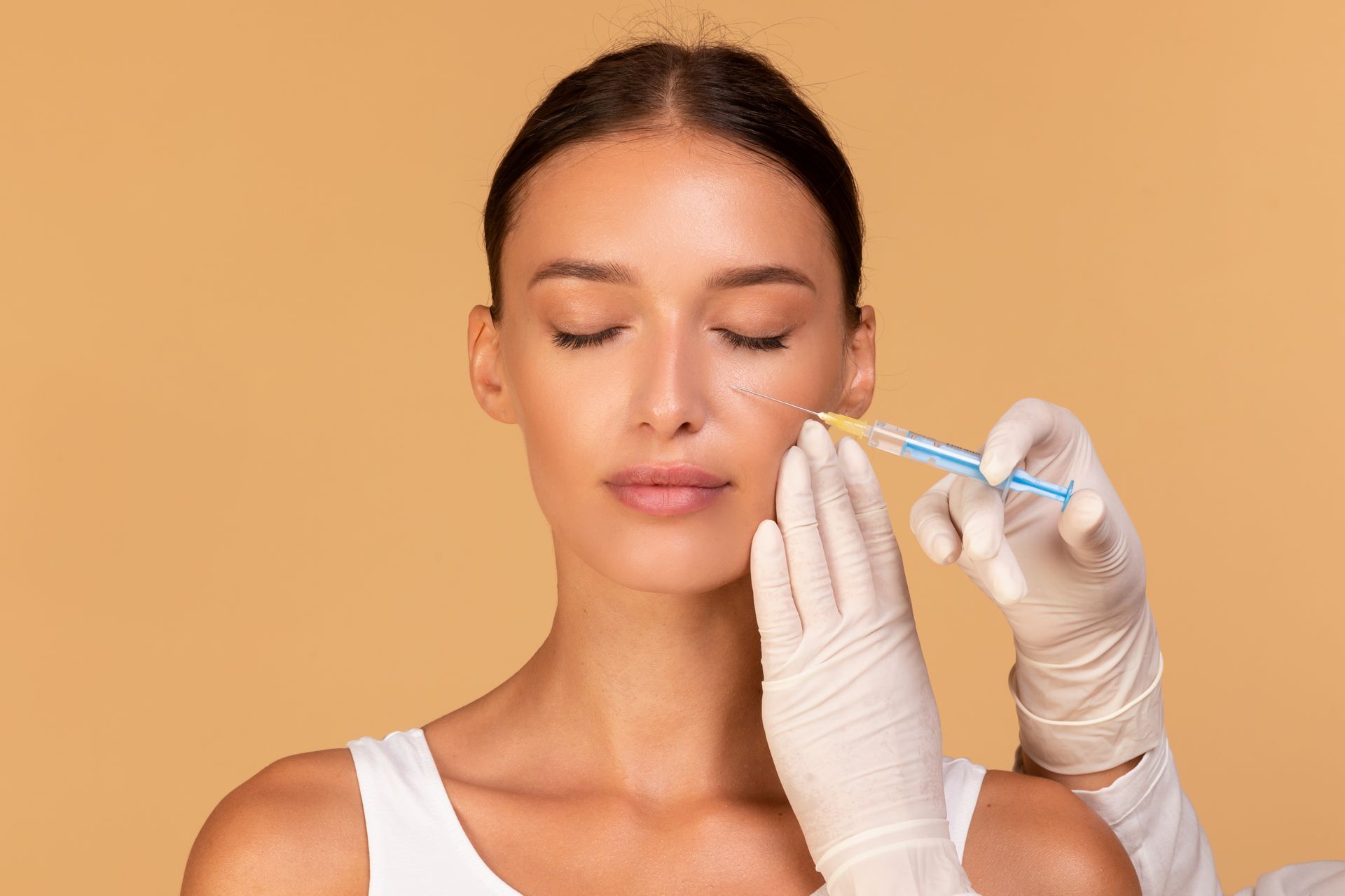 A woman is getting a botox injection in her face.