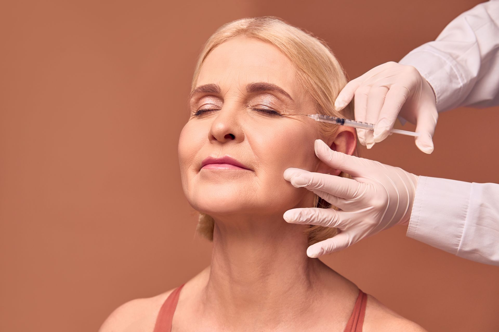 A woman is getting a botox injection in her face.