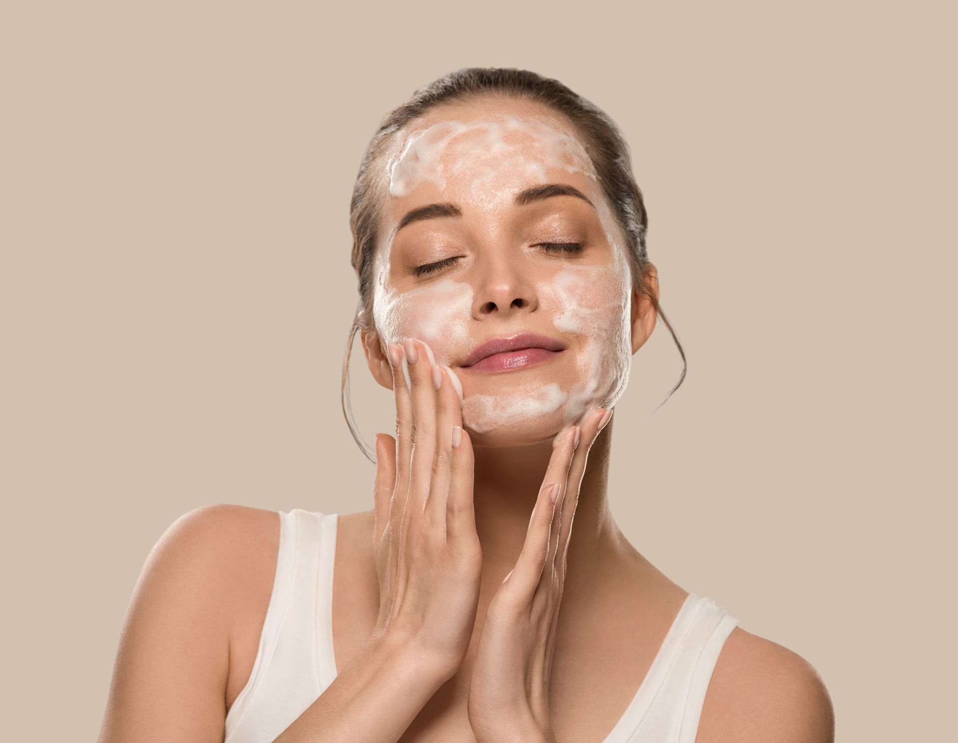 A woman is applying a facial mask to her face.
