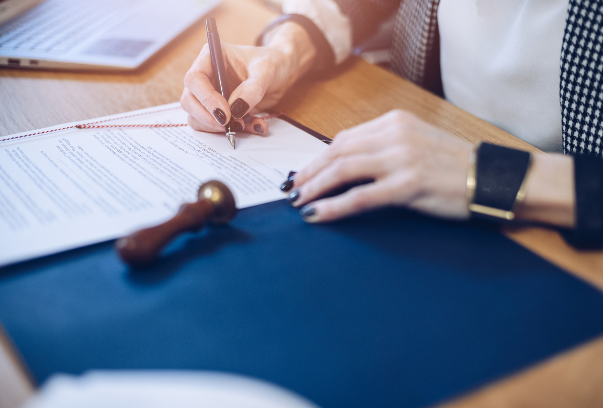 A woman is writing on a piece of paper with a pen.