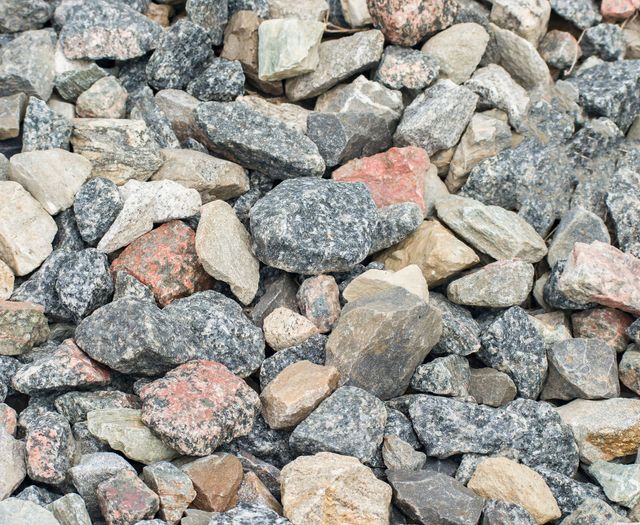 Gravel driveway beside a green lawn, leading toward a house garage.