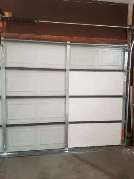 Closed white garage door with metal frame in a garage interior