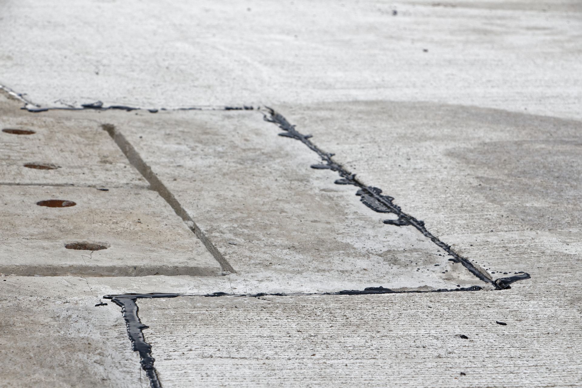 Longitudinal crack in residential asphalt driveway before hot rubber treatment