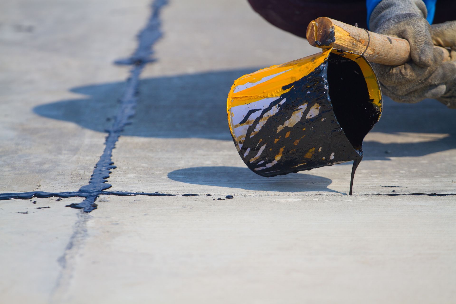 Longitudinal crack sealed flush with hot rubber sealant, residential driveway