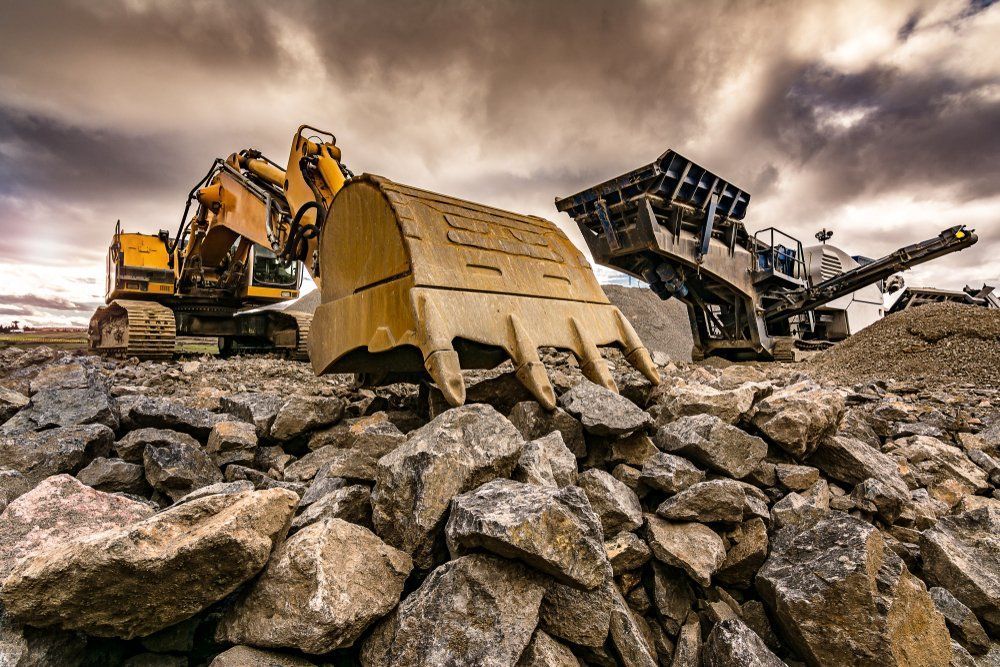 A Large Excavator Is Sitting On Top Of A Pile Of Rocks — ACC Excavations & Demolition Pty Ltd In Ulladulla, NSW