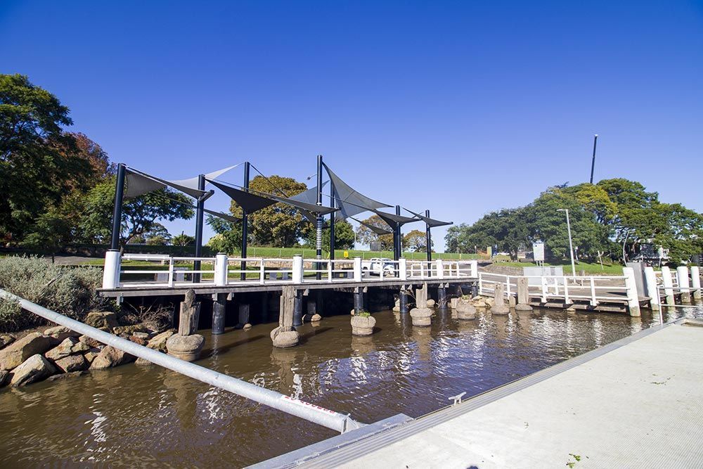 A Bridge Over a Body of Water With Trees in the Background — ACC Excavations & Demolition Pty Ltd In Nowra, NSW