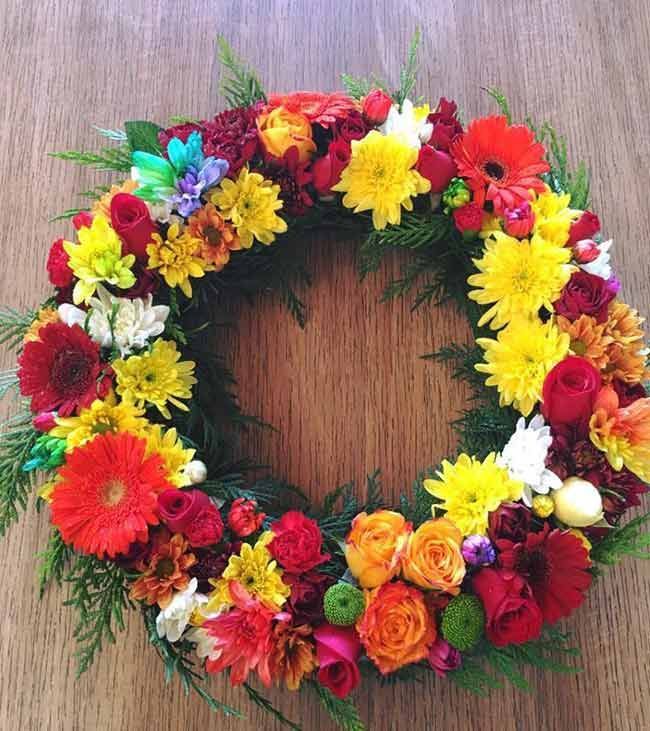 A Wreath of Colorful Flowers is Sitting on a Wooden Table — Flower Hunt in Robina, QLD