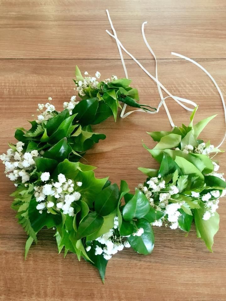 A Wreath of Green Leaves and White Flowers on a Wooden Table — Flower Hunt in Robina, QLD