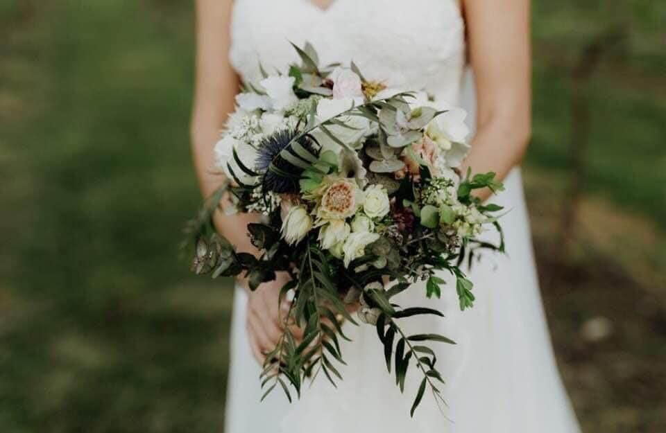 A Bride in a White Dress is Holding a Bouquet of Flowers — Flower Hunt in Robina, QLD