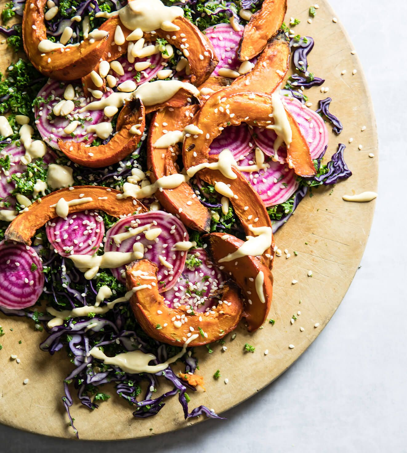 Roasted squash and purple cabbage salad with seeds on a beige plate