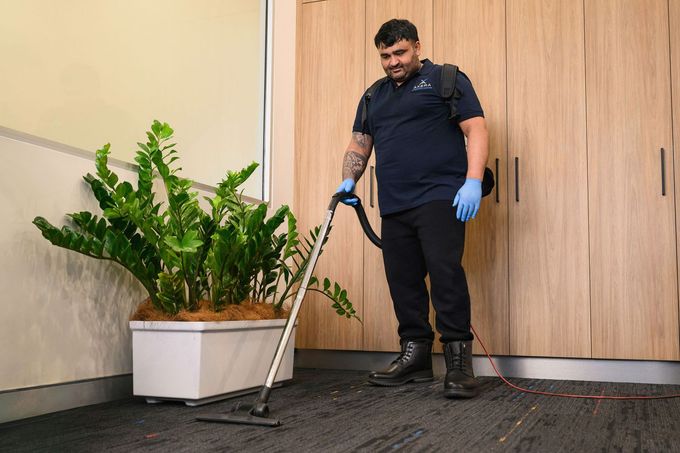 Commercial cleaner vacuuming carpet in an office