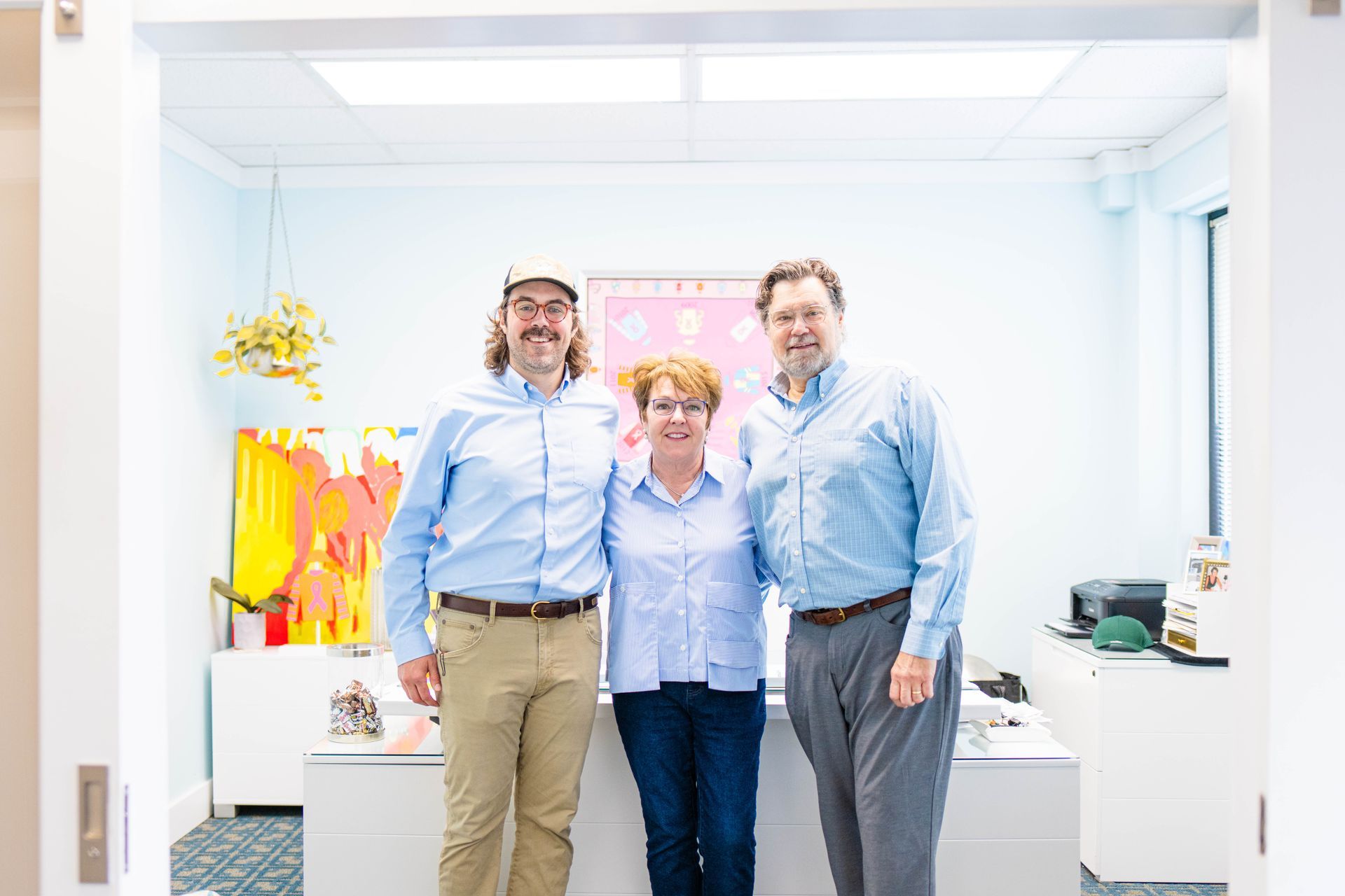 Three people are posing for a picture in a room.