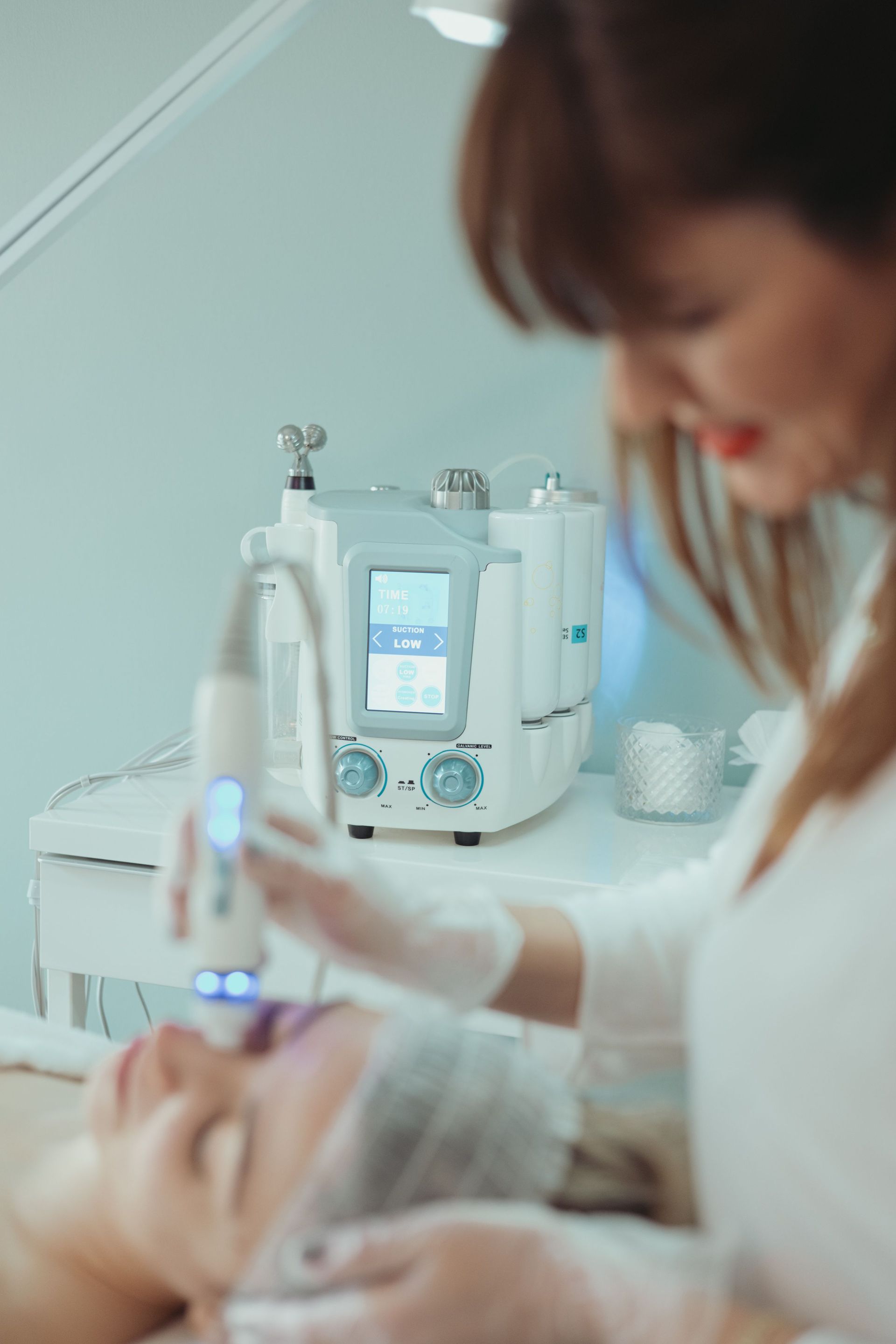 Aesthetic facial treatment in progress as a clinician operates a facial device in a med spa or clinic.