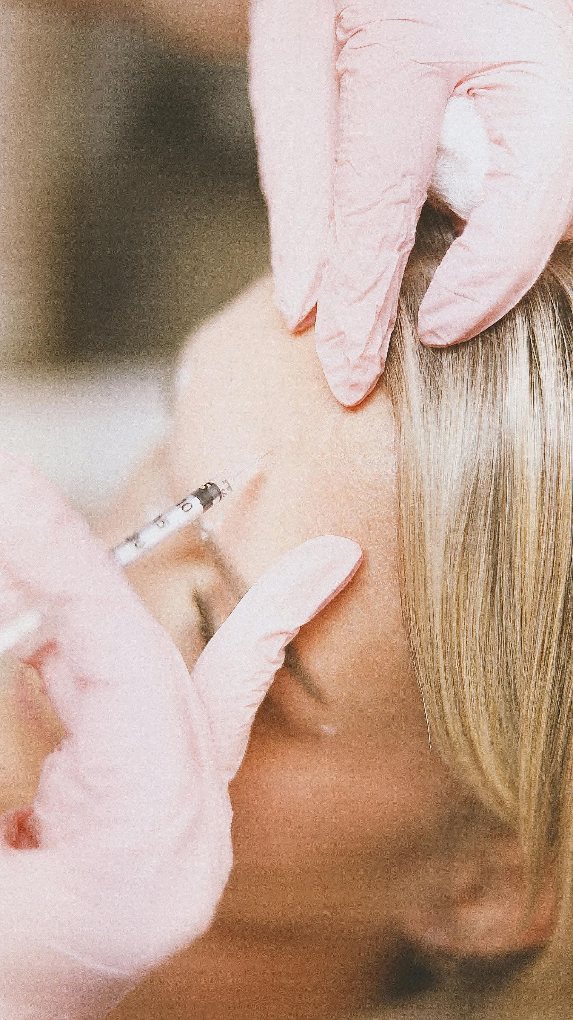 Cosmetic injection near a woman’s forehead during a facial treatment
