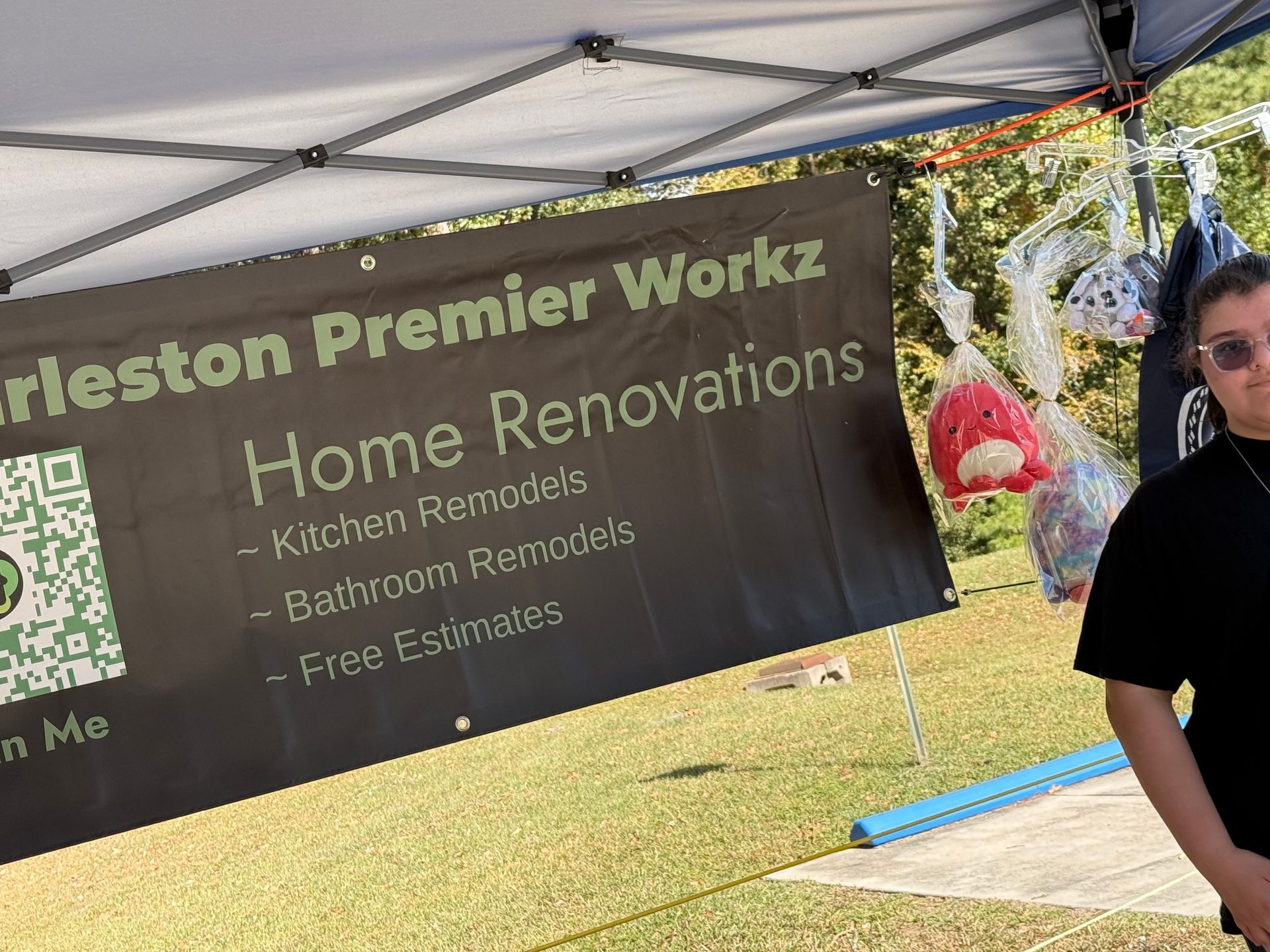 Charleston Premier Workz home renovations banner under a canopy, with a person standing at right