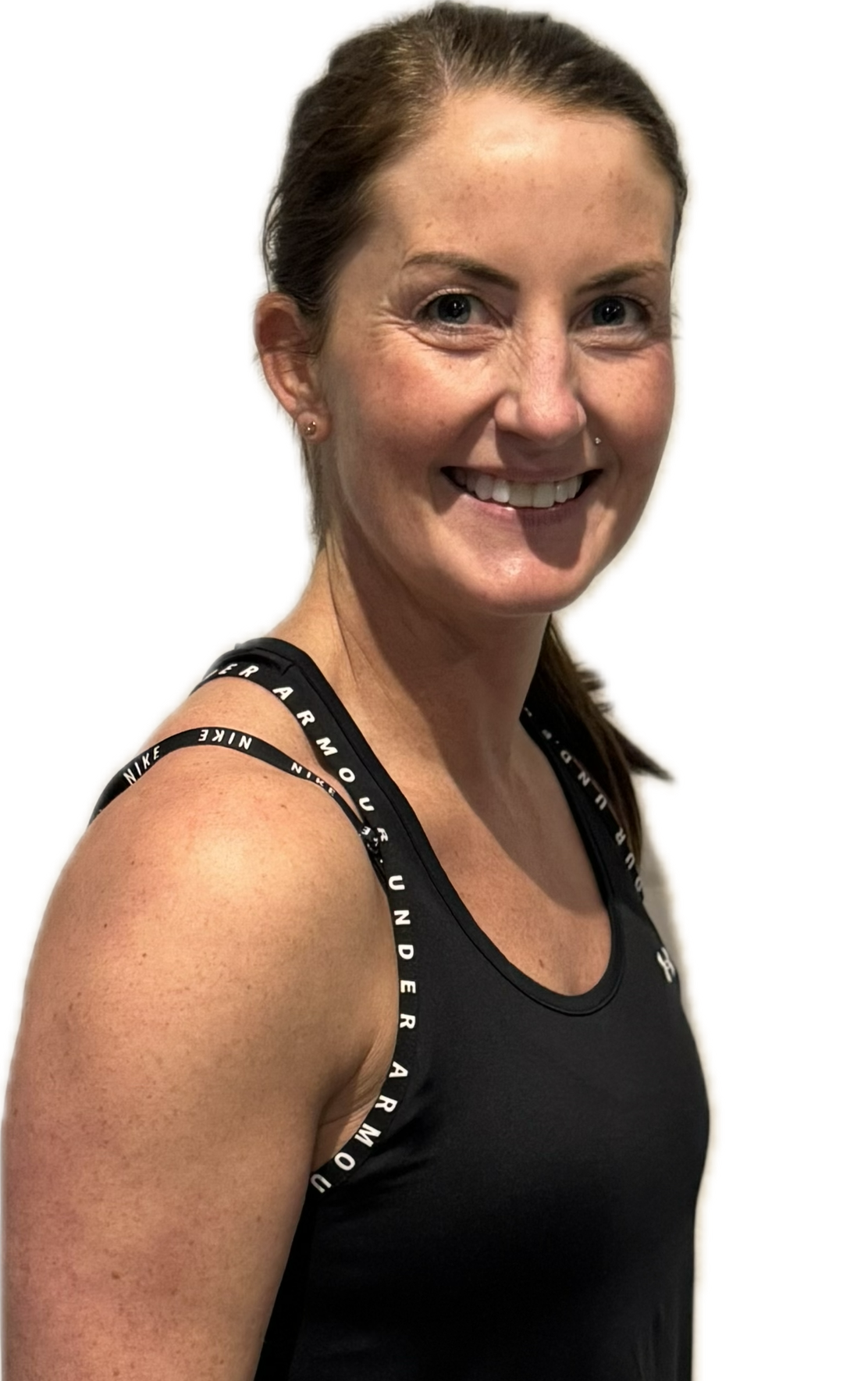Woman in black workout clothes points to her side, smiling.