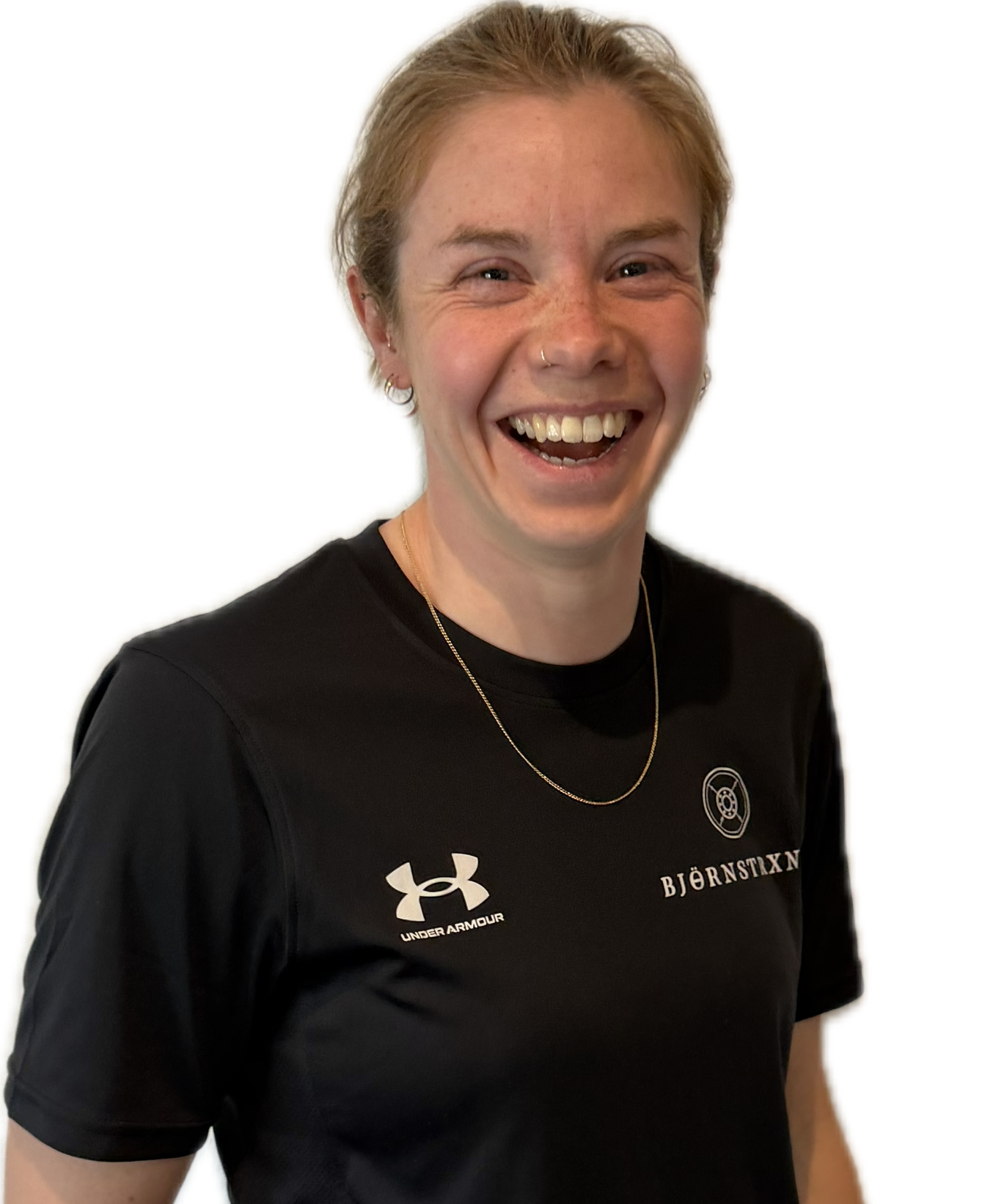 Woman in black workout clothes points to her side, smiling.