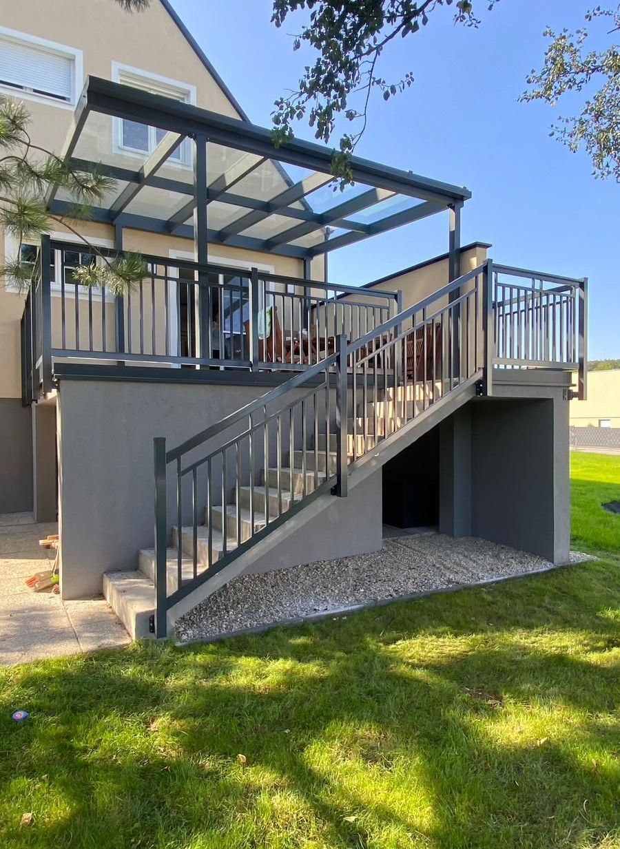 Ein Haus mit einem Balkon und einer Treppe, die dorthin führt.