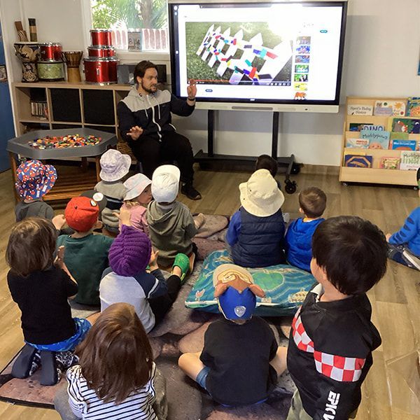 An educator is teaching a group of students — Mt Ousley Pre School in Fairy Meadow, NSW
