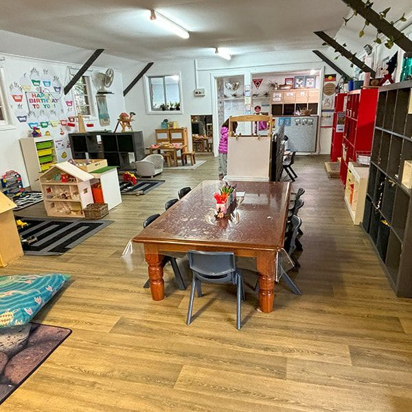A Large Room With a Table and Chairs in It — Mt Ousley Pre School in Fairy Meadow, NSW
