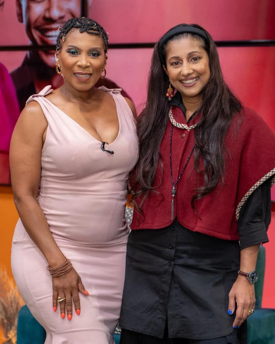 Penny Lebyane and Tricia Moodley smile side-by-side on a television set.
