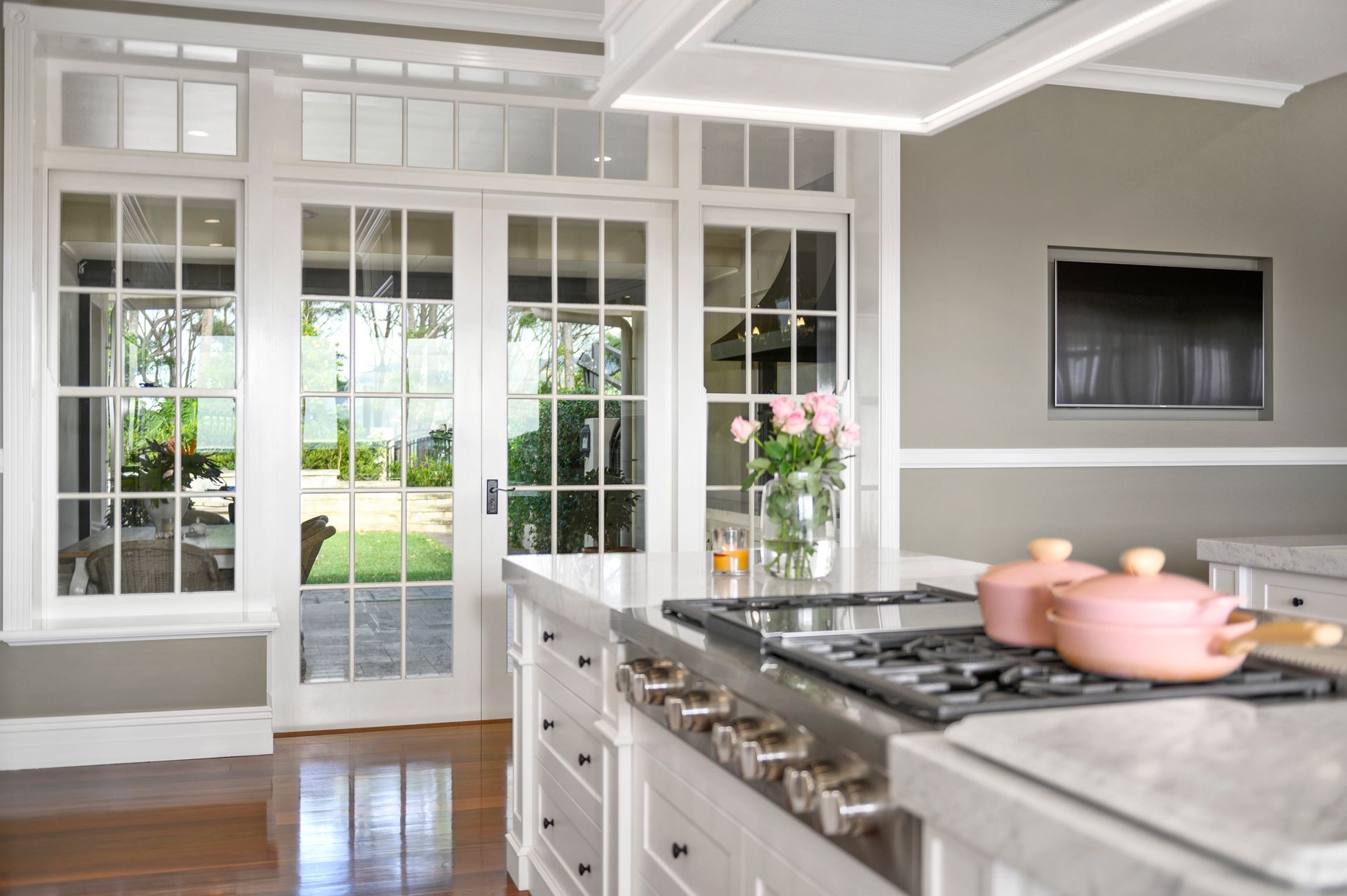 A Kitchen With White Cabinets And A Large Window — Plumbe Joinery in Coffs Harbour, NSW