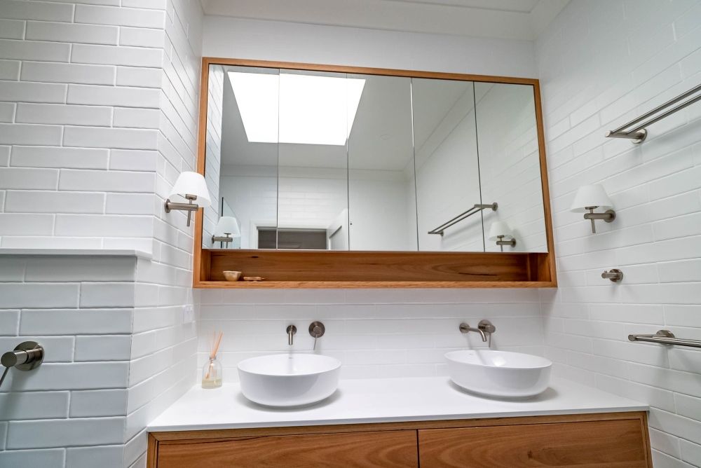 A Bathroom With Two Sinks And A Large Mirror — Plumbe Joinery in Coffs Harbour, NSW