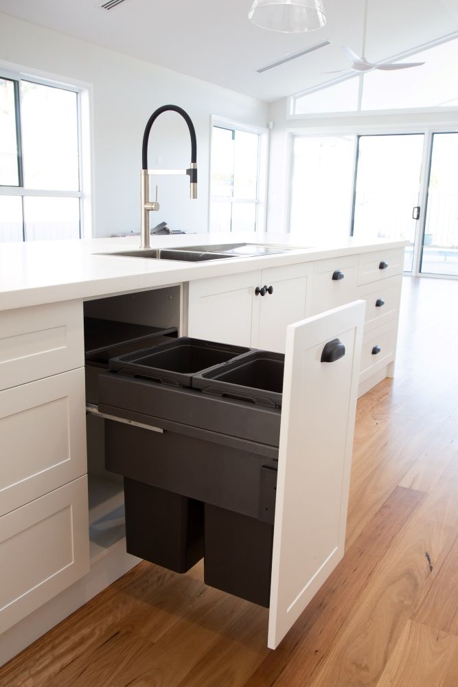 A Kitchen With White Cabinets And Black Drawers And A Sink — Plumbe Joinery in Coffs Harbour, NSW