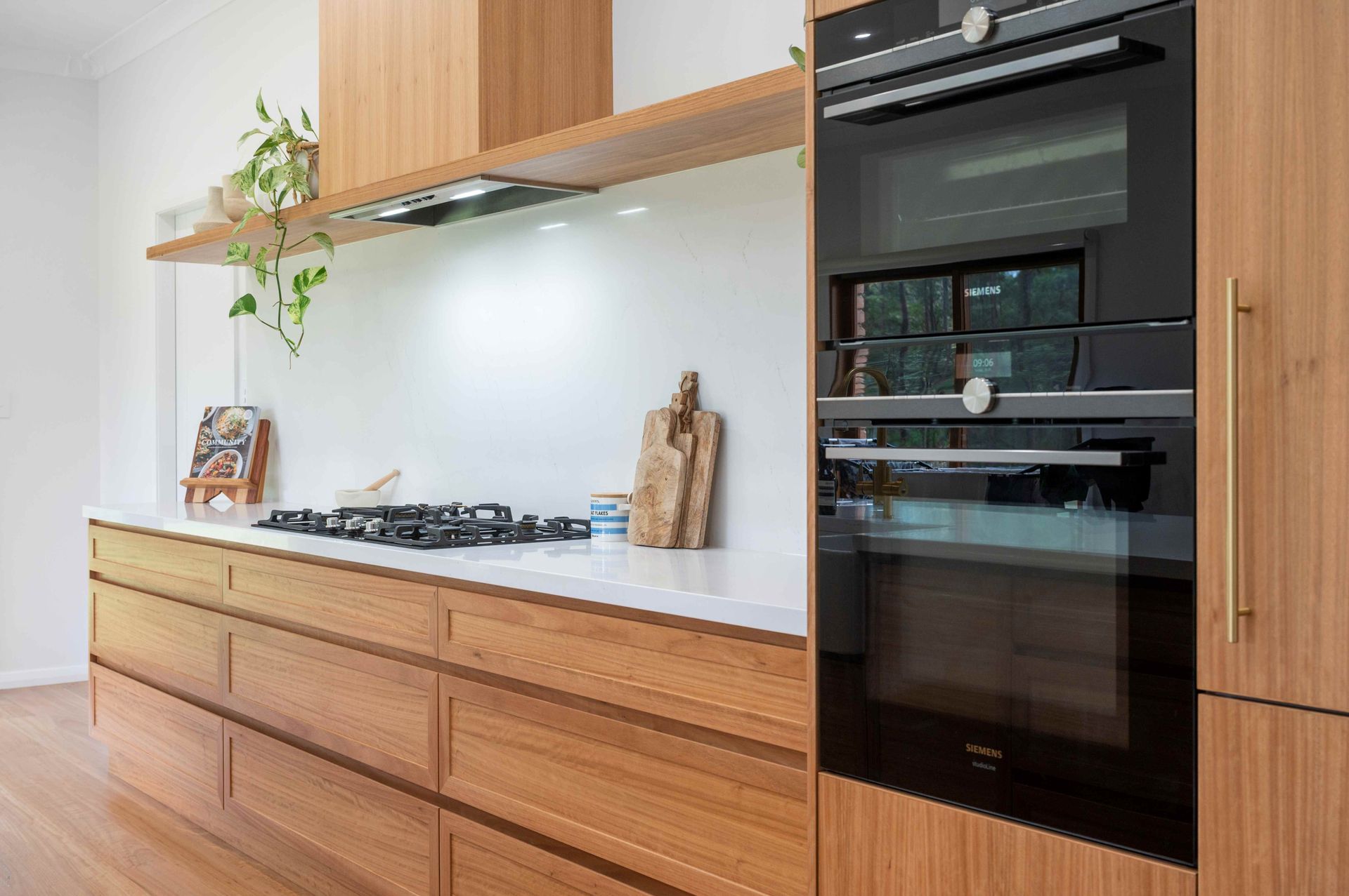 A white Kitchen With A chopping board and cook book — Plumbe Joinery in South West Rocks, NSW