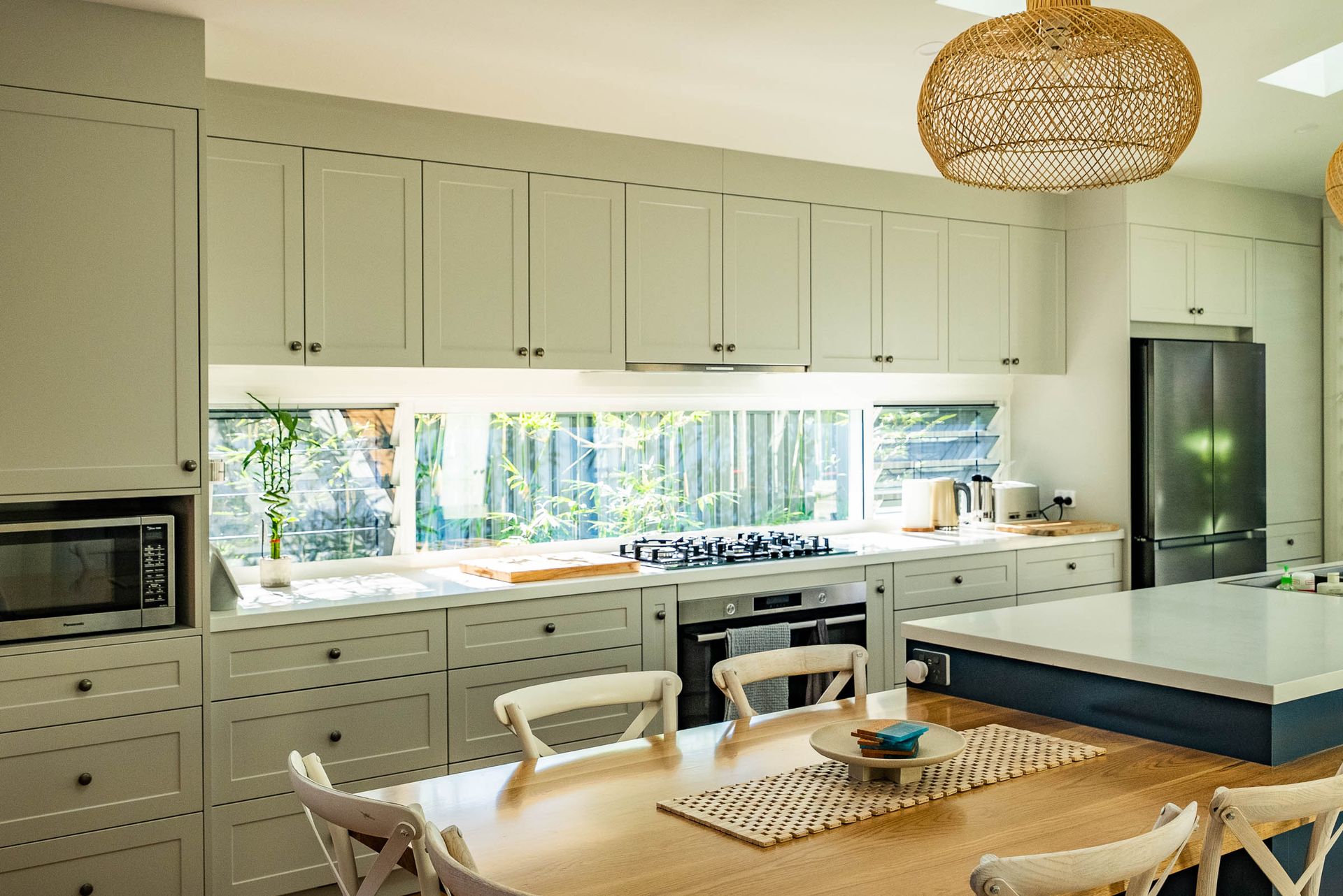 A Large Key Lime Kitchen space with cabinetry and dining table — Plumbe Joinery in South West Rocks, NSW
