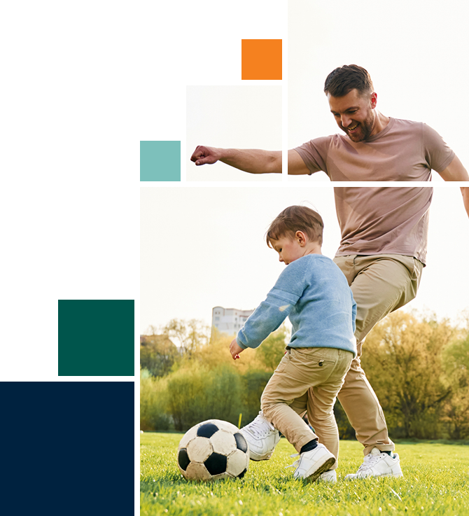 A man and a little boy are playing with a soccer ball in a field.