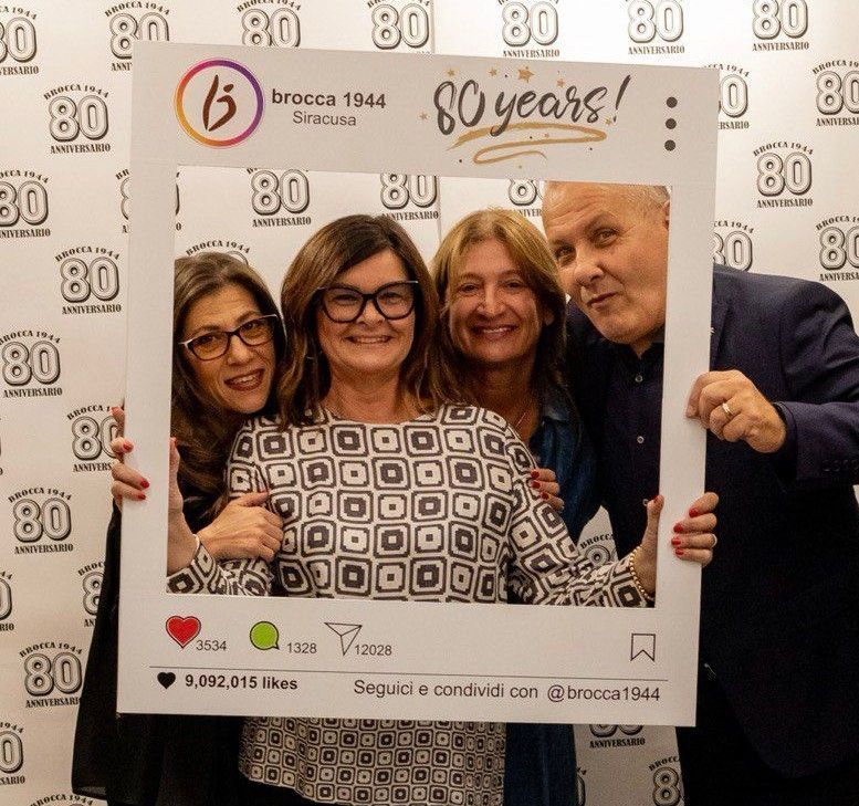 Due uomini sorridenti dietro una cornice per foto con la scritta 