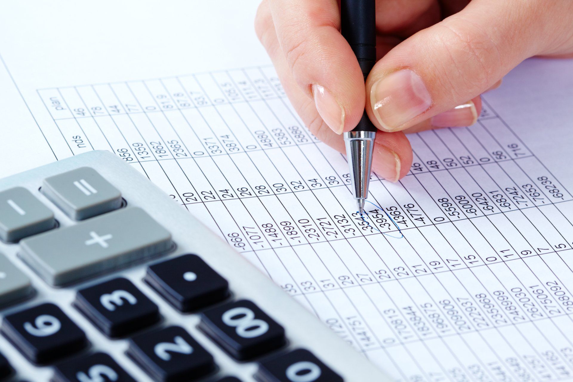 female hand holding pen over financial document for Harrisburg Property Management Group