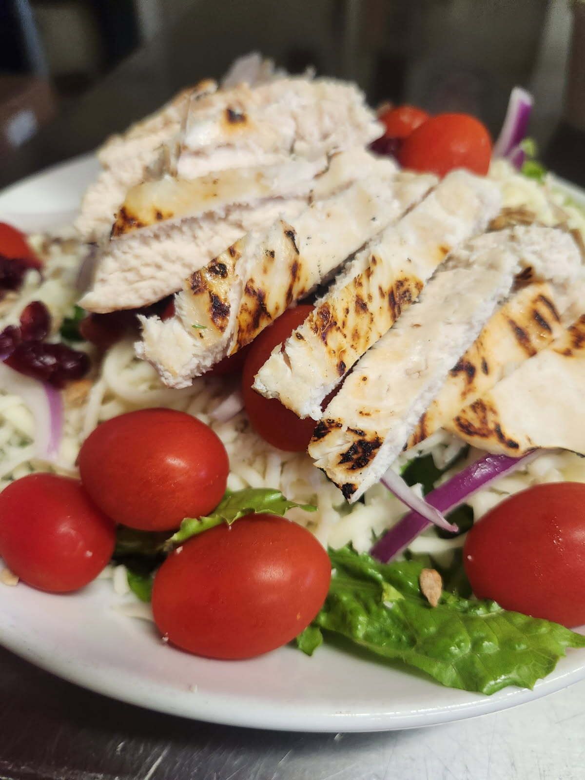 Breadsticks in a basket with a red and white checkered liner on a wooden table.